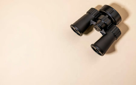 Binoculars black on a beige backgroundの素材