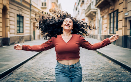 Beautiful young woman with flying hair in the city. Portraitの素材