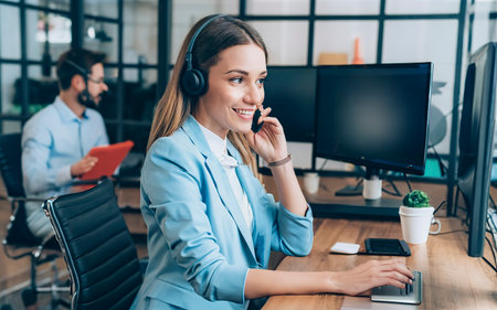 selective focus of happy call center operator in headset working at workplaceの素材