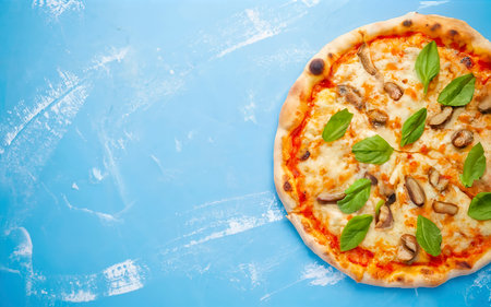 whole pizza fresh hot on a blue background. Top view, flat layの素材
