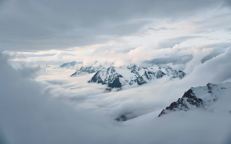 Wonderful minimalist landscape with big snowy mountain peaks above low clouds.の素材