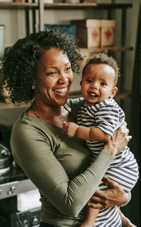 Medium shot happy black mother holding babyの素材