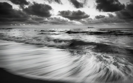 A close up of some waves in the middle of the ocean in black and white with copy spaceの素材