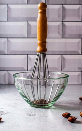 kitchen whisk in an empty glass bowl on the table. food backgroundの素材