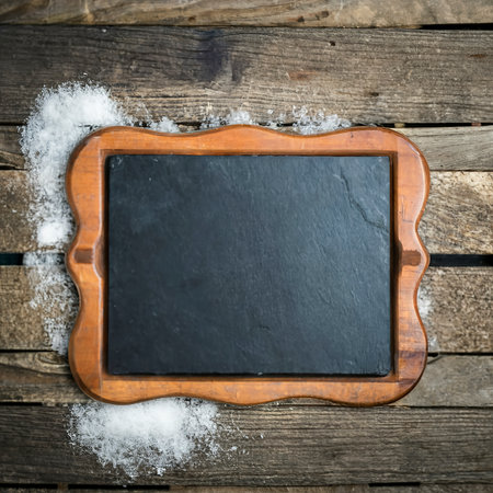 Black board of slate on old rustic wooden background, with snowの素材
