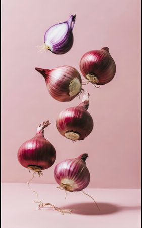 Fresh red onion bulbs falling on light coral backgroundの素材