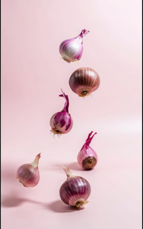 Fresh red onion bulbs falling on light coral backgroundの素材