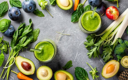 Green fruits and leafy vegetables smoothies in two glasses, green vitamin drink for detox and getting skinny dietの素材