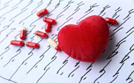 Red heart with pills on cardiogram. Cardiology conceptの素材
