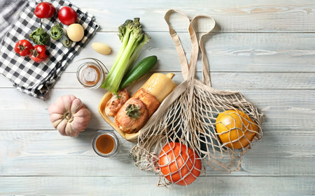 Shopping bag with food on a white table. Top view, flat lay.の素材