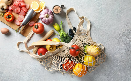 Shopping bag with food on a white table. Top view, flat lay.の素材