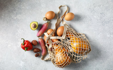 Shopping bag with food on a white table. Top view, flat lay.の素材