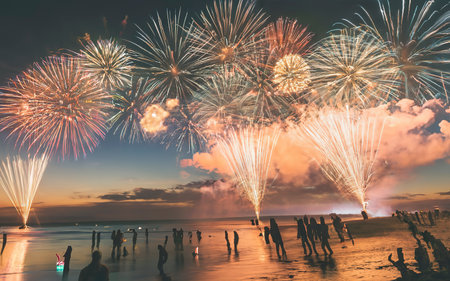 Fireworks with silhouettes of people in a holiday events. New Year fireworks on the beachの素材