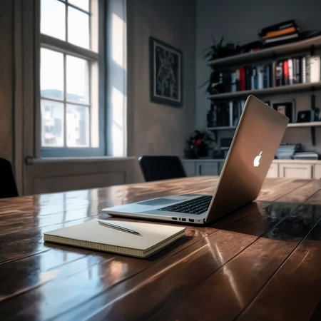 Laptop by a notepad on a wooden table in the officeの素材