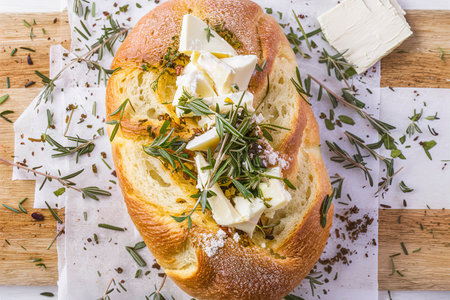 Bread with herbs and cheese on a cutting boardの素材