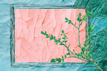 Frame with textured pink background on blue with branch of green thujaの素材