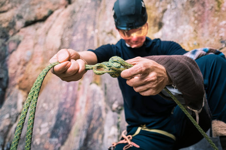 a rock climber holds out knotted ropeの素材