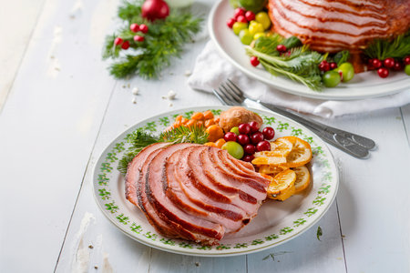 Christmas spiral ham served on a plate for holiday dinner with vegetables on the sideの素材