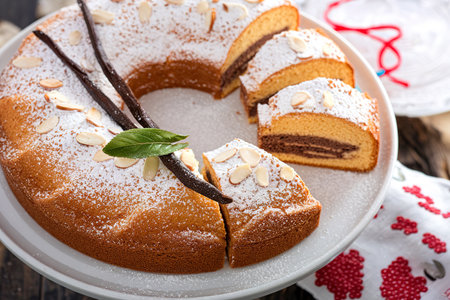 Vanilla, chocolate and almond cake on a cake stand powdered with sugarの写真素材