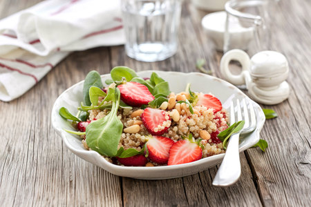 Quinoa salad with strawberries, pine nuts and greensの写真素材