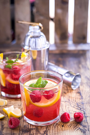 Red berry summer cocktail with lemons and raspberryの写真素材