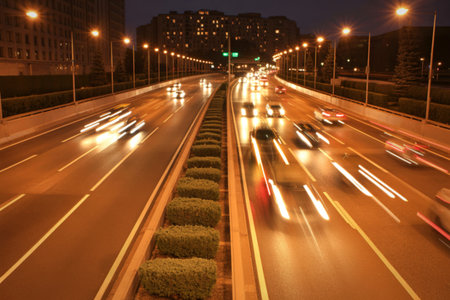 A long exposure captures the motion of vehicles on a multi-lane highway at night, creating streaks...