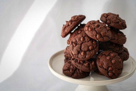 A close-up shot of a tall stack of freshly baked chocolate chip cookies, showcasing their rich texture and chocolatey goodness.の写真素材