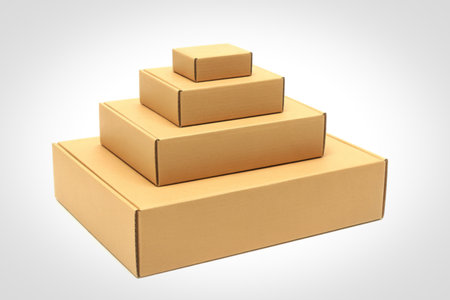 A pyramid of four brown cardboard boxes, each smaller than the one below, neatly stacked against a white background.の写真素材