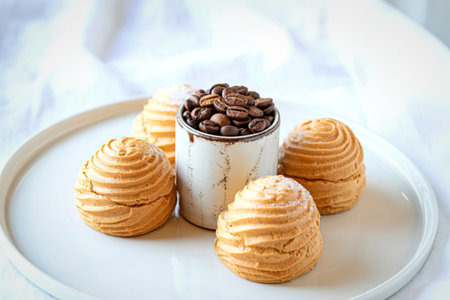 A festive Easter dessert arrangement featuring golden, swirled pastries resembling eggs surrounding a jar filled with roasted coffee beans.の写真素材