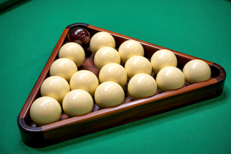 A wooden triangle rack holds a full set of white billiard balls, neatly arranged on a green felt...