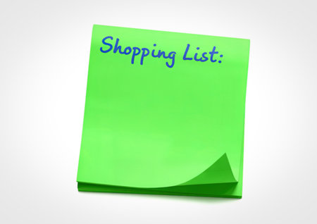 A bright green sticky note with the words Shopping List written in blue ink. The note is slightly curled at the bottom.の写真素材