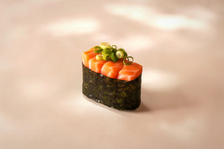 A single piece of gunkan maki sushi with chopped salmon and fresh green onions on top, presented on a textured surface.の写真素材