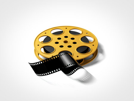 A close-up shot of a golden vintage film reel with a black film strip partially unspooled, casting a subtle shadow on a white background.の写真素材