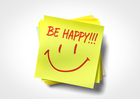 A bright yellow sticky note with the words "BE HAPPY!!!" and a hand-drawn smiley face, conveying a positive and cheerful message.の写真素材