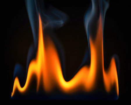 Intense orange and yellow flames rise upwards with wisps of smoke against a deep black backdrop,...