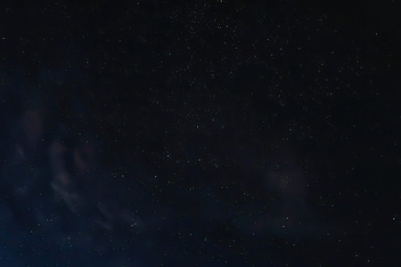 A breathtaking image of a dark night sky filled with numerous stars and a hint of a galaxy, creating...