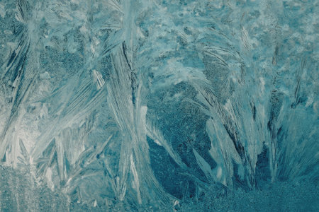 The image displays a detailed view of ice formation with intricate patterns and textures. The ice appears to have a blue hue and features various shapes and formations.の写真素材