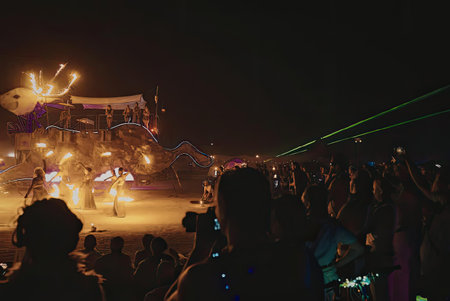 The image captures a vibrant scene at night with a large crowd of people observing a brightly...