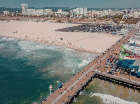 An aerial view of a vibrant beachside pier with a colorful amusement park, surrounded by a sandy...
