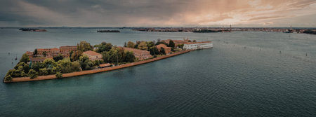 An aerial view of a small island with buildings and trees surrounded by waterの写真素材