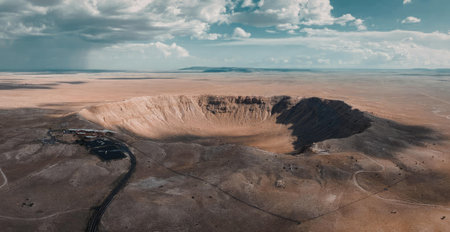 An aerial view of a vast volcanic crater with a dark rocky interior and a stream flowing through the...
