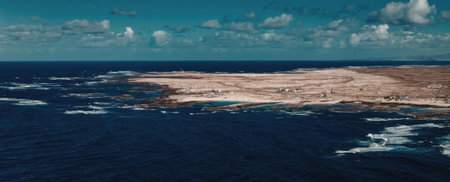 An aerial view of a coastal landscape featuring a large body of water and a sandy shoreline under a...