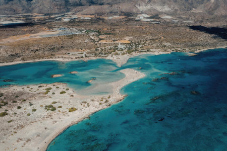 An aerial view of a tropical beach with clear blue waters and a sandy shore