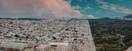 An aerial view of a city with a mountain range in the background. The city is densely populated with...