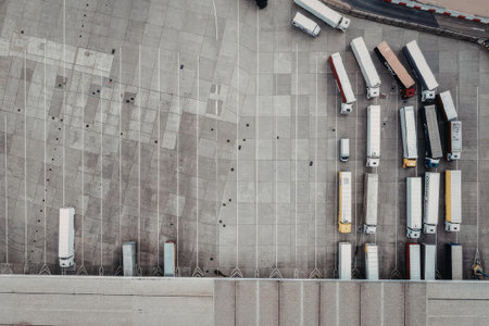 An aerial view of trucks on a concrete surface, showcasing various colors and arrangements.