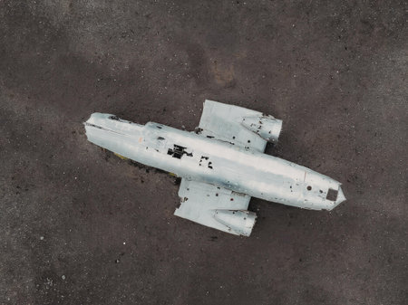 The image depicts a damaged aircraft component, likely a missile or drone, lying on a dark gray...