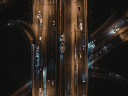 An aerial view of a busy highway interchange at night, with multiple roads and interchanges...