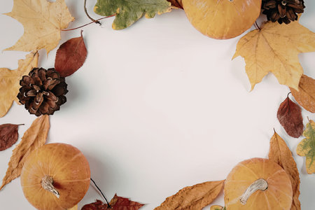 Autumn leaves and pumpkins frame on white background