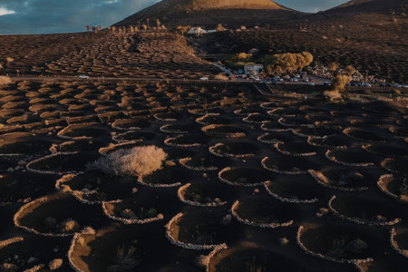 A landscape of distinctive basalt columns formation with a mountain in the background during sunset.の写真素材