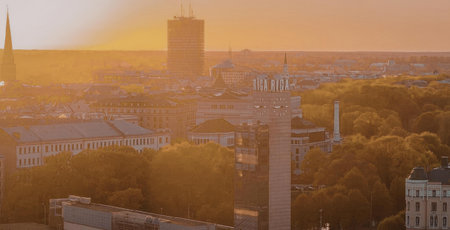 A city skyline during sunset with buildings and trees in the foreground